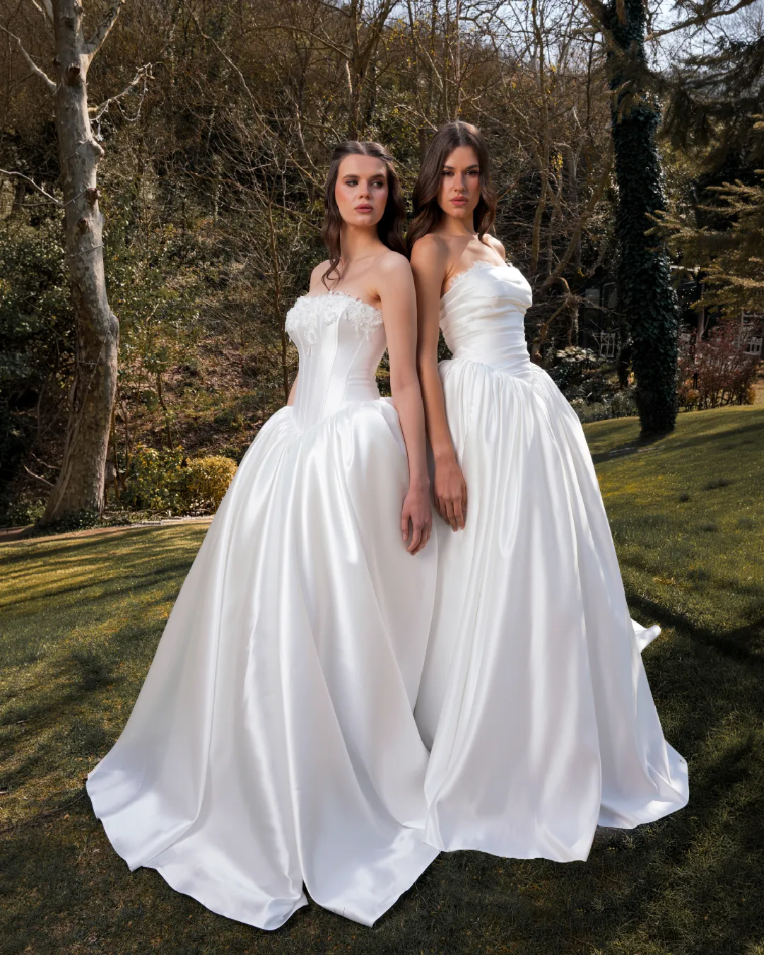 Yan yana duran iki model ve hacimli beyaz gelinlikler